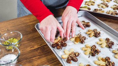 Dikkatlice paketlenmiş Noel kurabiyeleri, çikolataya batırılmış ve şeffaf selofan ambalajla sunulmuş, bayram hediyesi olarak mükemmel..