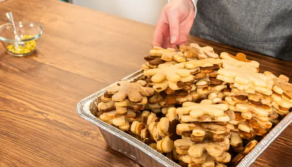 Kar taneleri şeklinde altın renkli kurabiyeler. Karmaşık bir şekilde istiflenmiş..