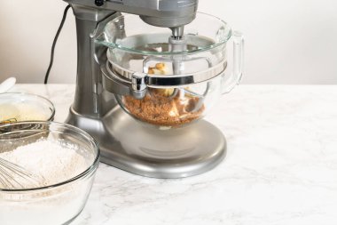 Cam kaseyle karıştırıcıyı göz hizasında görmek, klasik zencefilli kurabiye kurabiyesinin malzemelerini karıştırmak. Görünür katmanlar koyu pekmez karışımı ve kahverengi şeker, birleştirilmeye hazır.