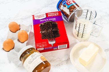 Denver, Colorado, ABD-7 Eylül 2023 mutfak tezgahının üzerinde toplanan çikolatalı kekler elverişli bir kek karışımı ve enfes bir karışım kullanarak karşı konulmaz çikolatalı kekler yapmak için gerekli malzemeler.