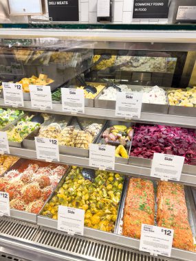 Castle Rock, Colorado, ABD-22 Şubat 2025 iyi stoklanmış Whole Foods şarküterisi çeşitli taze ve hazır gıdalar sergiliyor. Seçeneklerde kızarmış sebze ve makarna gibi yan yemekler yer alıyor.