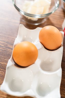 Bir dizi malzeme titizlikle ahşap bir masanın üzerine yerleştirilmiş ve karamel şekerle süslenmiş nefis bir zencefilli keke dönüştürülmeye hazır..