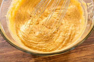 Bardak karıştırma kabında, büyük bir el çırpma ustalıkla lezzetli zencefilli kek ve karamel kremalı pasta malzemelerini karıştırır..