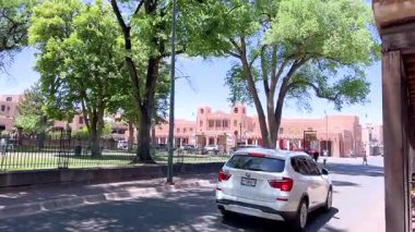 Santa Fe, New Mexico, ABD-Haziran 1, 2024-Ağır çekim-A, Santa Fe, New Mexico 'da geleneksel kerpiç mimarisi ve canlı mavi pencere çerçeveleriyle kaplı bir yürüyüş yolu. Yol çizili.