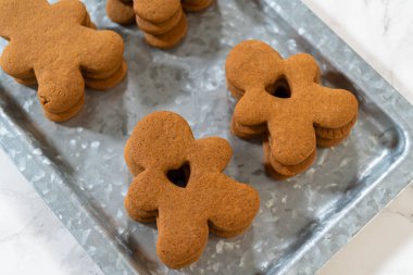 Zencefilli kurabiyeler, kalp şeklinde kesilmiş zencefilli bir adam, mermer bir tezgahın karşısında kırsal metal bir tepside dinleniyor..