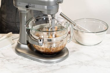 Cam bir kaseyle karıştırma işlemi sırasında baharatlı zencefilli kurabiye için mükemmel hamur işi karışımı. Esmer şeker ve tereyağı pürüzsüz bir hamur için bir araya getiriliyor..