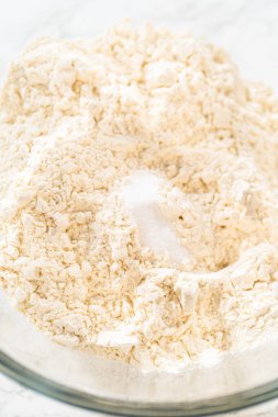 Klasik Şekerli Kurabiye Hamuru, un ve şeker de dahil olmak üzere kuru malzemelerin yakın çekim görüntüsü kasede dokulu bir karışım gösteriyor. Bu makro atış un dokusunun ince detaylarını yakalar.