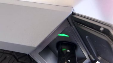 Denver, Colorado, ABD-28 Nisan 2024. Tesla Cybertruck 'ın şarj edildiği yakın çekim görüntüsü. Araç portuna bağlı şarj kablosu.