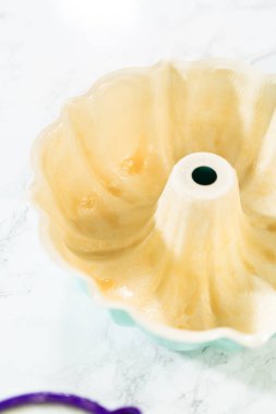 Kek tepsisini pişirmeye hazırlamak için, eritilmiş sebze boyası ve un karışımı ustalıkla uygulanır, kolay salınımını sağlar ve güzel pişmiş bir kek paketidir..