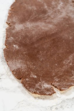 Solgun zencefilli kurabiye için düz hamurun genel görünümü Un bir mermer yüzey üzerinde kurabiyeler, eldiven şekilleri kesmek için hazırlandı.