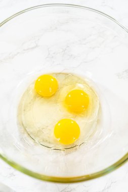 Büyük bir cam kasede, malzemeler harika havuçlu kek pişirmek için ustalıkla karıştırılır..