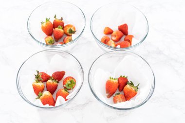 Taze yıkanmış ve kurutulmuş çilekler kağıt havluyla kaplı cam bir kasede dikkatlice düzenlenir. Atıştırmaya ya da daha fazla kullanılmaya hazır hale getirilir..