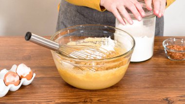 Bardak karıştırma kabında, büyük bir el çırpma ustalıkla lezzetli zencefilli kek ve karamel kremalı pasta malzemelerini karıştırır..