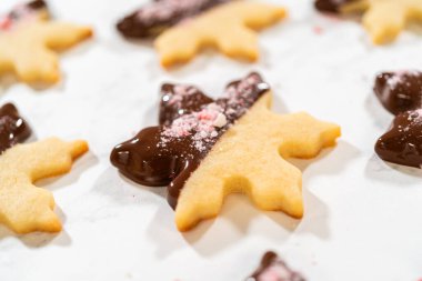 Parşömen kağıdında ezilmiş nane şekeriyle kaplı çikolata soslu kar tanesi şekerli kurabiyenin yakın çekimi..