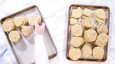 Düz yatıyordu. Kadın özenle, hamur karışımı şekerlemelerle dolu şekerli kurabiyeleri kırsal kahverengi bir karton kutuya yerleştiriyor..