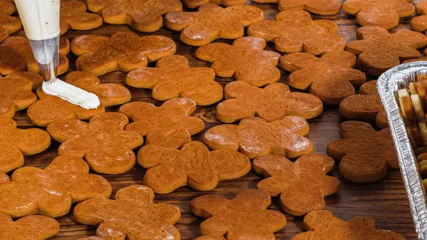 Zencefilli kurabiye sandviçi ve yumurta likörlü tereyağı. Noel hediyesi olarak sade bir ahşap masada sunuluyor..