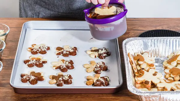 Çikolataya batırılmış ve çeşitli malzemeler serpiştirilmiş yıldız şeklinde tatil kurabiyeleri..