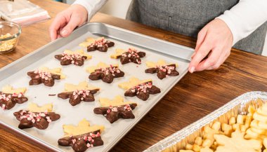 Yıldız şeklinde kurabiyeler hazırlıyorum, çikolataya yarı daldırılmış, bayram için naneli çikolata parçacıkları ile aksanlı..