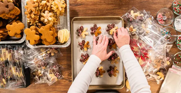 Dikkatlice paketlenmiş Noel kurabiyeleri, çikolataya batırılmış ve şeffaf selofan ambalajla sunulmuş, bayram hediyesi olarak mükemmel..