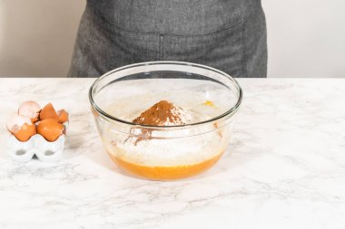 Sıcak bir mutfakta, büyük bir karıştırma kabı malzemelerin ustalıkla harmanlanması için sahne olur, kek karışımından nefis bir ev yapımı balkabağı pastası hazırlamak için sahne hazırlar.