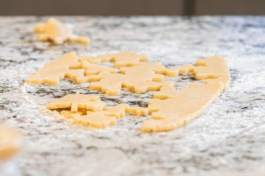 Kurabiye hamuru serpiştirme ve kar tanesi şeklindeki şeker kurabiyelerini kesme geleneğinin tadını çıkarın. Tatil sezonu için mükemmel..