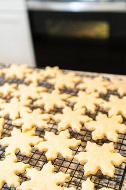 Lezzetli kar tanesi şekilli şekerli kurabiyeleri rafta soğutup onları Noel hediyelerine hazırlıyorum..