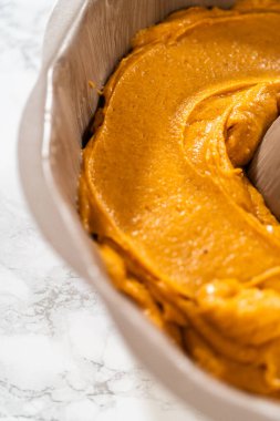 Pasta hamurunu kek tepsisine dökerek nefis bir ev yapımı balkabağı pastası yapmaya hazır..