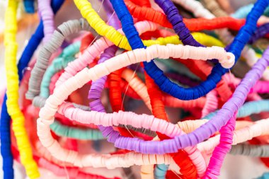 Beyaz bir masadaki renklere göre düzenlenmiş canlı bir kil boncuk koleksiyonu genç zanaatkarlara kendi eşsiz bileziklerini yapmaları için ilham vermeye hazır..