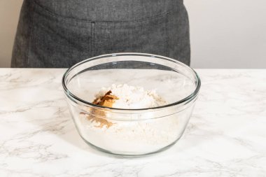 Klasik zencefilli kurabiye hamuru, un, kabartma tozu ve tarçın, zencefil ve karanfil gibi baharatlar içeren kuru malzemeler içeren bir karışım kasesinin göz hizasında görüntüsü. Bu malzemeler...