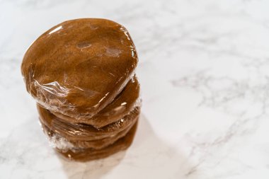 Plastik ambalaja sarılı baharatlı zencefilli kurabiye için mükemmel hamur. Hamur kolay idare ve soğutma için bölünmüş, yuvarlanmaya ve şekillendirilmeye hazır..