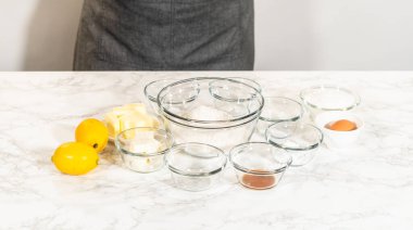 Limon spritz kurabiyelerinin tüm malzemeleri tereyağı, un, limon lezzeti, yumurta ve baharat da dahil olmak üzere ayrı kaselerde hazır ve nazır..