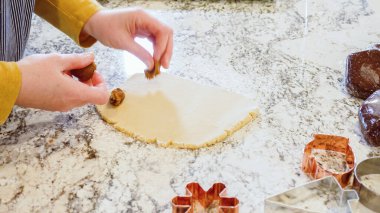 Modern bir mutfaktaki zarif mermer tezgahın üzerine zencefilli kurabiye hamuru sermek için ayarlanabilir bir merdane kullanmak, bayram pişirme şenliğine hazırlanmak....