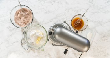 Elektrik mikseri ve ince baharat aromalı Solgun Zencefilli Kurabiyeler için hazırlanmış kuru ve ıslak malzemelerle donatılmış. Un karışımında bir çırpı duruyor, birleştirmeye hazır.