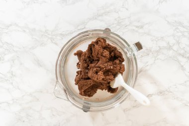 Çikolata Ginger Şekerli Kurabiye Hamuru 'nun bir kısmının üst görüntüsü mermer tezgahın üzerine yerleştirilmiş, yanında bir spatula duruyor, şekillendirmeye ya da soğutmaya hazır..