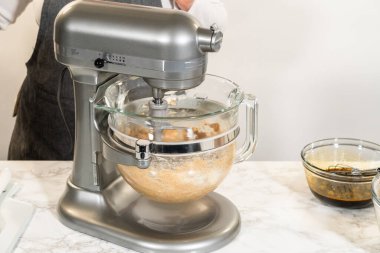 Çikolatalı Zencefilli Kurabiye Hamuru 'nun malzemelerini karıştırmak için kullanılan bir tezgah. Karıştırma işlemi devam ediyor, zengin ve pürüzsüz bir kurabiye hamuru yaratıyor.