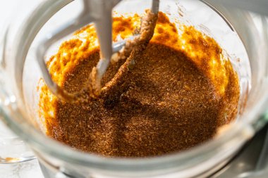 Lezzetli Turuncu Zencefilli Kurabiye Hamuru için tereyağı ve şekerle karıştırılmış pekmez karışımı. Zengin, koyu pekmez kremalı malzemelerle pürüzsüz bir şekilde birleşir ve derinlik katar.