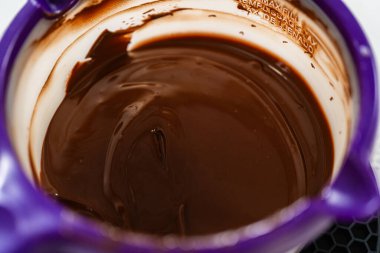 Mor bir eritme kabında pürüzsüz eritilmiş çikolata, naneli şekerli kurabiyeler için mükemmel hazırlanmış..
