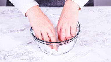 Çilekler, yeni yıkanmış ve kurutulmuş, cam bir kasede güzelce depolanmış kağıt havluyla kaplanmış ve tazeliği korumak için plastikle kaplanmış..