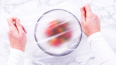 Düz yatıyordu. Çilekler, yeni yıkanmış ve kurutulmuş, cam bir kasede güzelce depolanmış kağıt havluyla kaplanmış ve tazeliği korumak için plastikle kaplanmış..