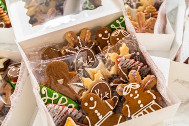 Kapalı bir perspektiften yakalanan açık bir Noel kurabiyesi hediye kutusu, içinde gülümseyen zencefilli kurabiye figürleri ve yıldızların da bulunduğu çok güzel düzenlenmiş zencefilli kurabiye kurabiyelerini gözler önüne seriyor.