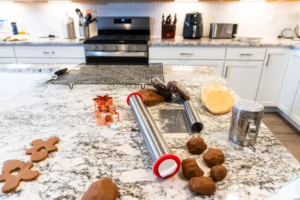 Çağdaş beyaz bir mutfakta zencefilli kurabiye hamuru ustalıkla sarılır ve nefis bir tatil ziyafeti için zemin hazırlar..