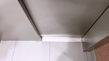 Bu resim bir otelin asansör girişinin sofistike tasarımını gözler önüne seriyor. Detaylı desenli bir duvar ve mimari güzelliği arttıran parlak bir metal süsleme var..