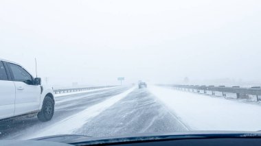 Denver, Colorado, ABD-15 Ocak 2024 'te birçok araç kör edici kar yağışı ve kaygan hava koşullarıyla karşı karşıya kalırken fırtınanın görüş mesafesini ve karayolu sınırlarını azaltmasıyla eyaletler arası seyahat ediyor.