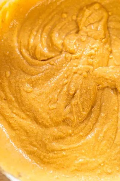 Bardak karıştırma kabında, büyük bir el çırpma ustalıkla lezzetli zencefilli kek ve karamel kremalı pasta malzemelerini karıştırır..