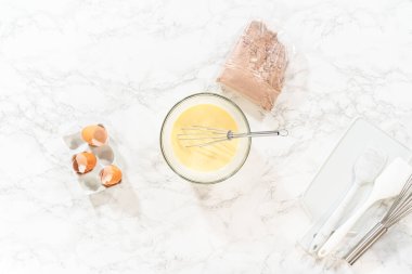 Düz yatıyordu. El çırpma makinesiyle, malzemeler cam karıştırma kabında ustalıkla karıştırılarak nefis bir çikolatalı kek elde ediliyor..