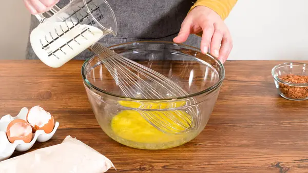 Bardak karıştırma kabında, büyük bir el çırpma ustalıkla lezzetli zencefilli kek ve karamel kremalı pasta malzemelerini karıştırır..