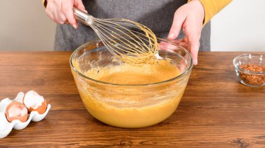 Bardak karıştırma kabında, büyük bir el çırpma ustalıkla lezzetli zencefilli kek ve karamel kremalı pasta malzemelerini karıştırır..