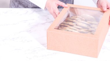 Hamurun içine şeker parçacıkları doldurulmuş olan kurabiyeler, özenle özenle hazırlanmış, kırsal kahverengi bir karton kutuya konur..