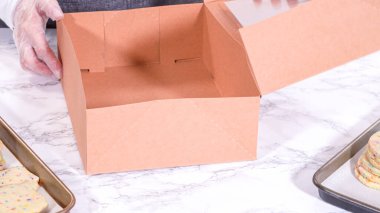 Hamurun içine şeker parçacıkları doldurulmuş olan kurabiyeler, özenle özenle hazırlanmış, kırsal kahverengi bir karton kutuya konur..