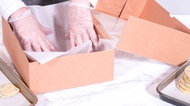 Hamurun içine şeker parçacıkları doldurulmuş olan kurabiyeler, özenle özenle hazırlanmış, kırsal kahverengi bir karton kutuya konur..